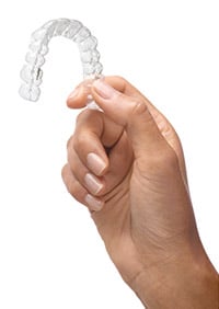 A woman holding an Invisalign tray in Canberra